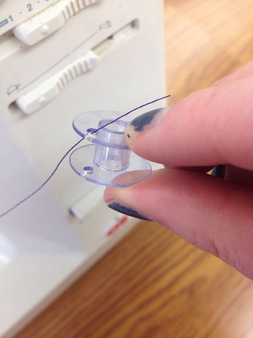 Pull the thread through the top hole on the bobbin.