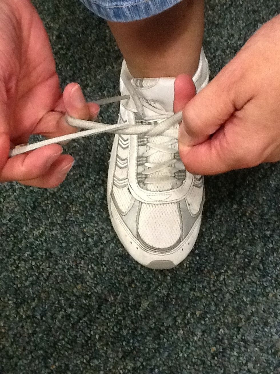 Pull the top lace under the lower lace.