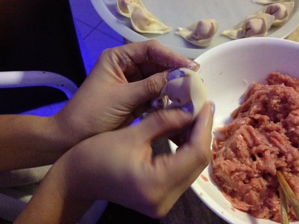 Pull the two corners towards the bottom whilst your fingers are still tucking in the sides - try to make it tight and make sure the mince isn't coming out anywhere