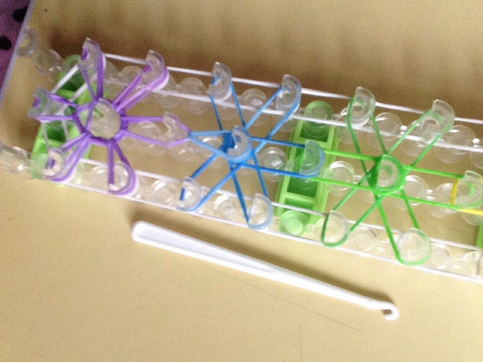 Pull under the purple and get the blue and pull that on towards the middle peg.