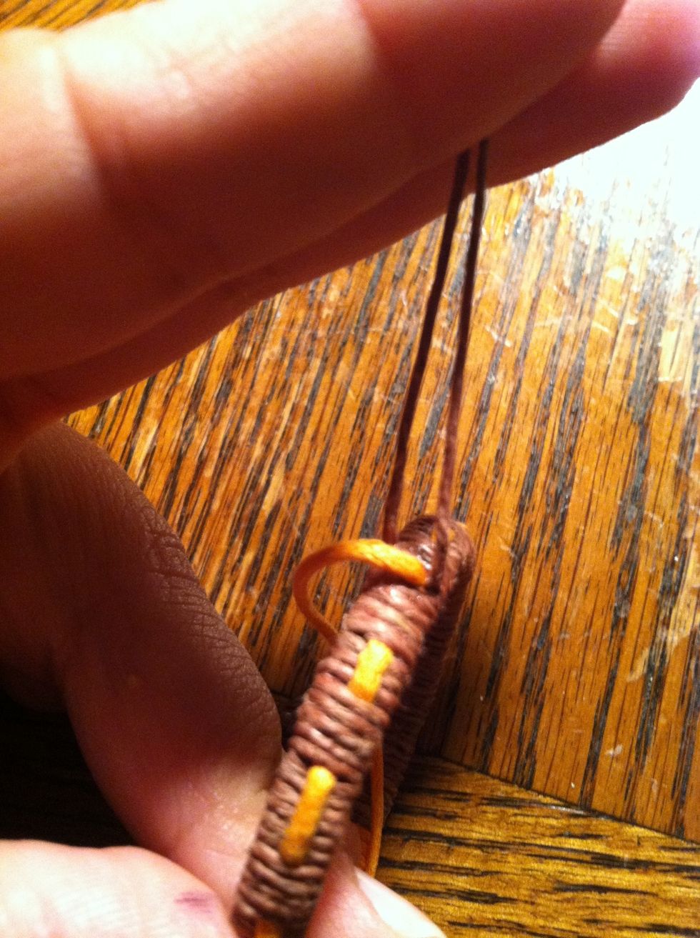 Pull you necklace strings up. You're going to be using your secondary string to wrap now. Start wrapping in a kind of figure eight. Under and over on either side of the necklace strings.