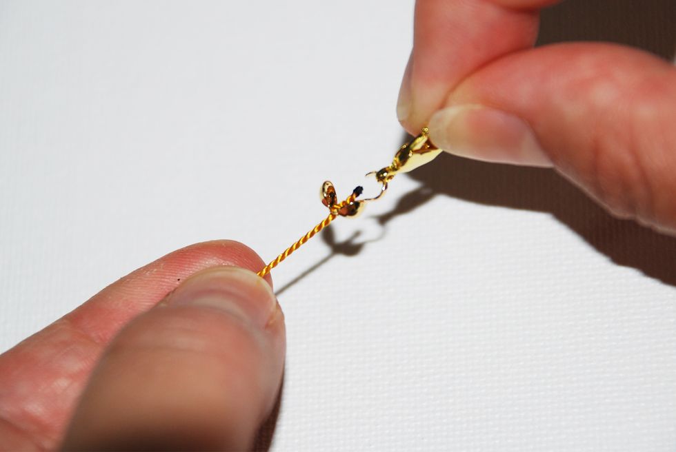 Pull your clasp into the hook of the clamshell end cap.