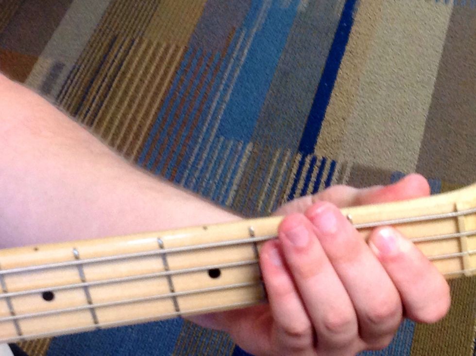 Pull your finger on the A string back while your preferred finger is in the spacing of the nut and the first fret on the neck. This is the first note in the scale, B flat.