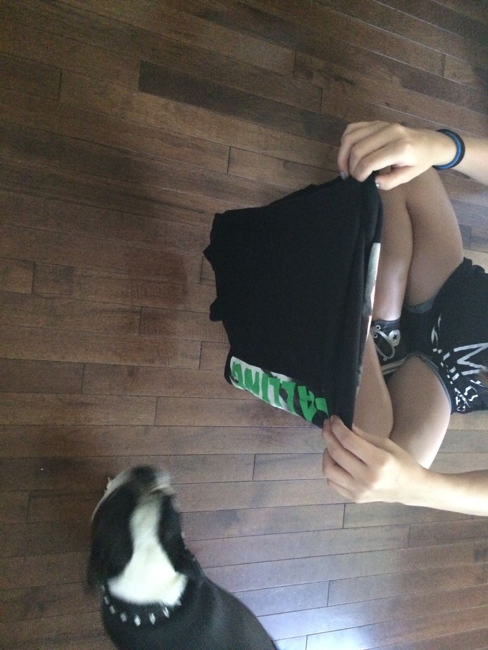 Pull your other hand through and hold the shirt up