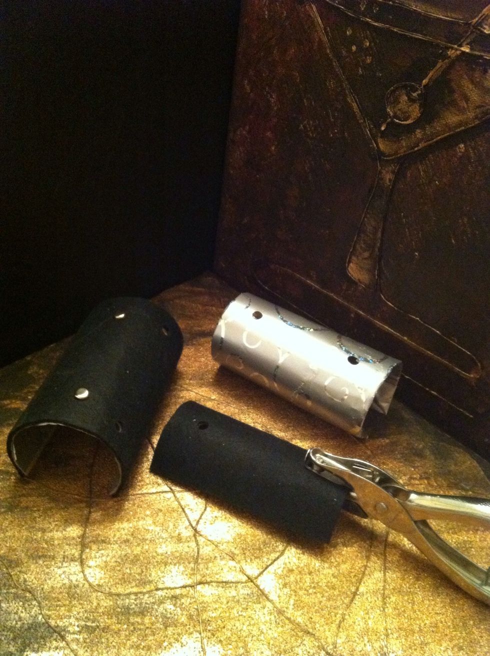 Punch 2 holes at the center bottom part of the roll. Repeat this step on the holder and base parts. Tip: Push the hole puncher as far in as possible for an even punch.