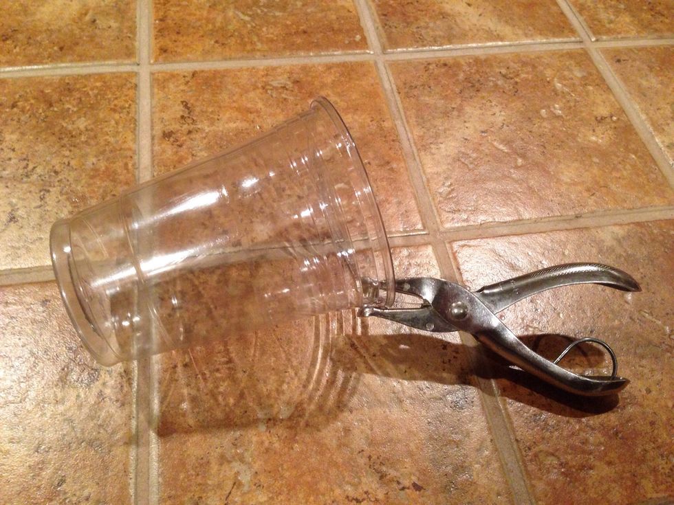 Punch a hole large enough near the rim of the cup that the hook can move in and out of it easily.