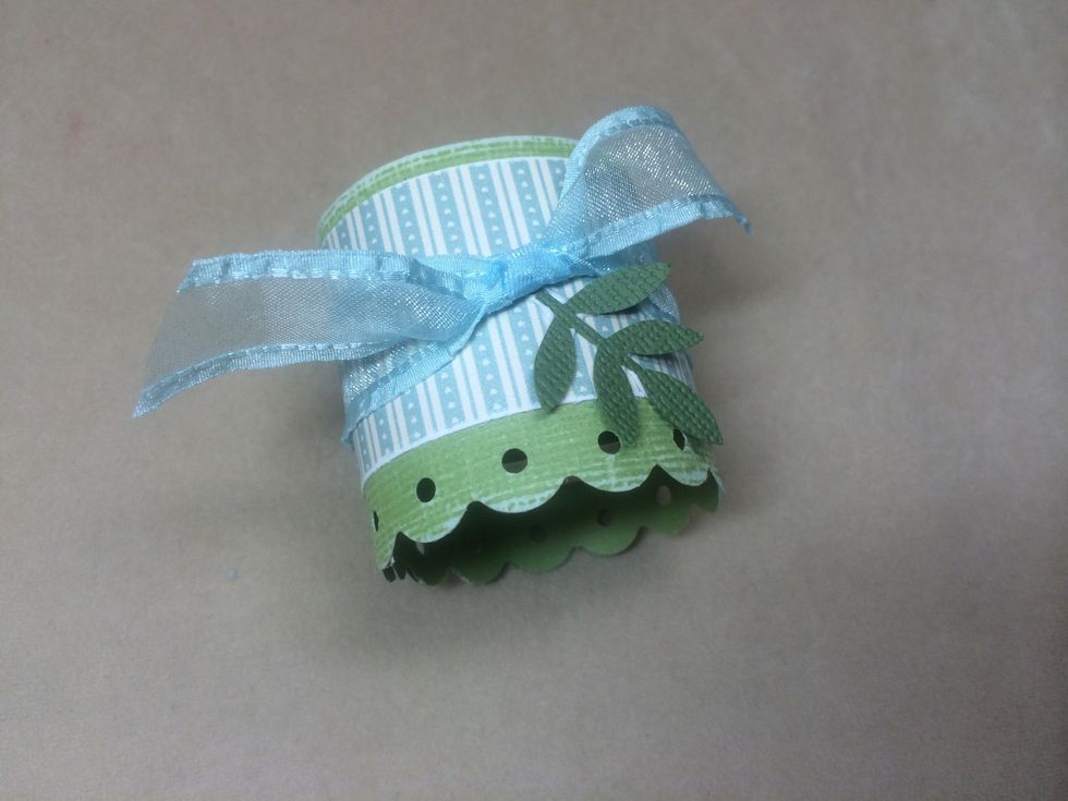 Punch a leaf shape from darker green card stock, curve a bit, then adhere just below knot.