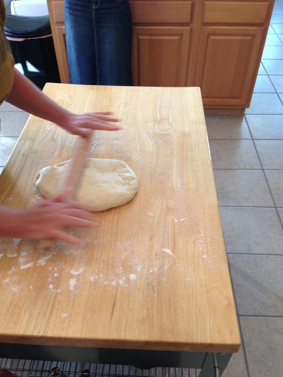 Punch down dough after rise and split Into two equal pieces Then roll out to about 1/2" thick