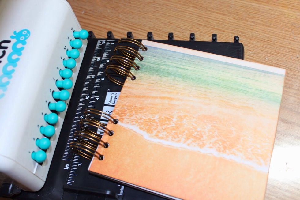 Punch holes in book components using binding tool and then bind book using coils.