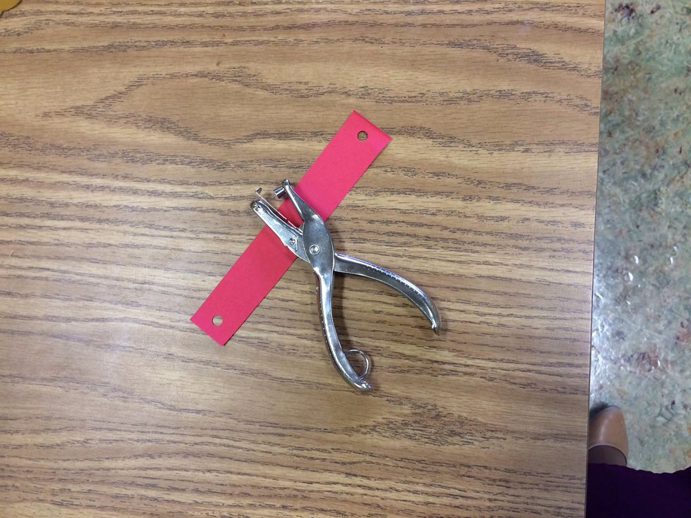 Punch holes in both the top and bottom of each paper strip.