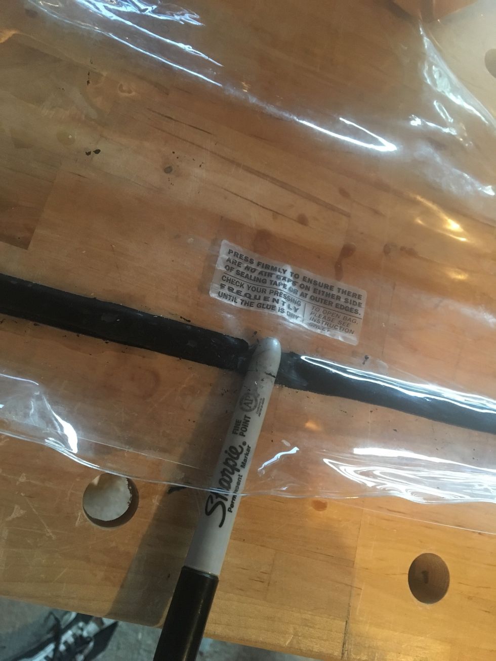 Push a blunt object between the sealing tape and the vacuum bag.