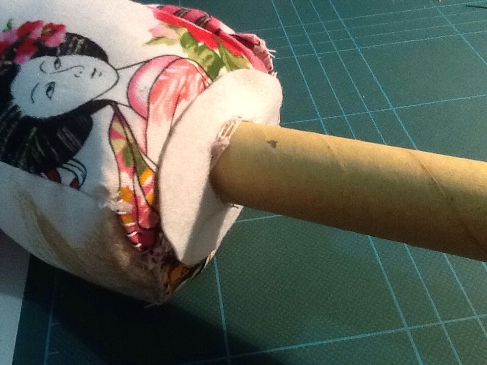 push it through the end of the tube, until it reaches the mannequin. Position it where you want it, so that it covers the stitches underneath. You can trim the end of the tube if it's too long.