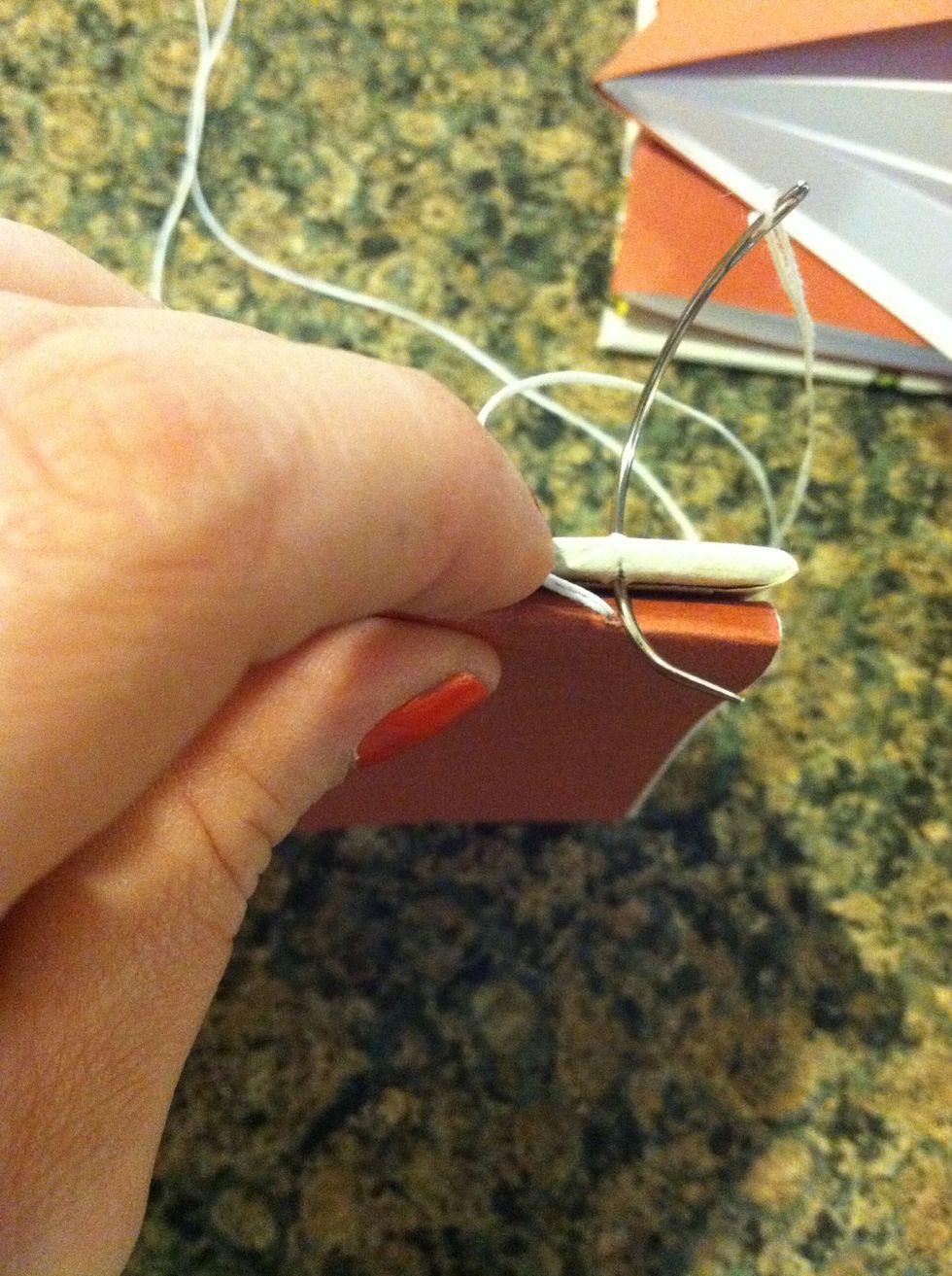 Push needle through first station in cardboard OUTSIDE to the INSIDE pull tread tight (but don't pull the tail out)