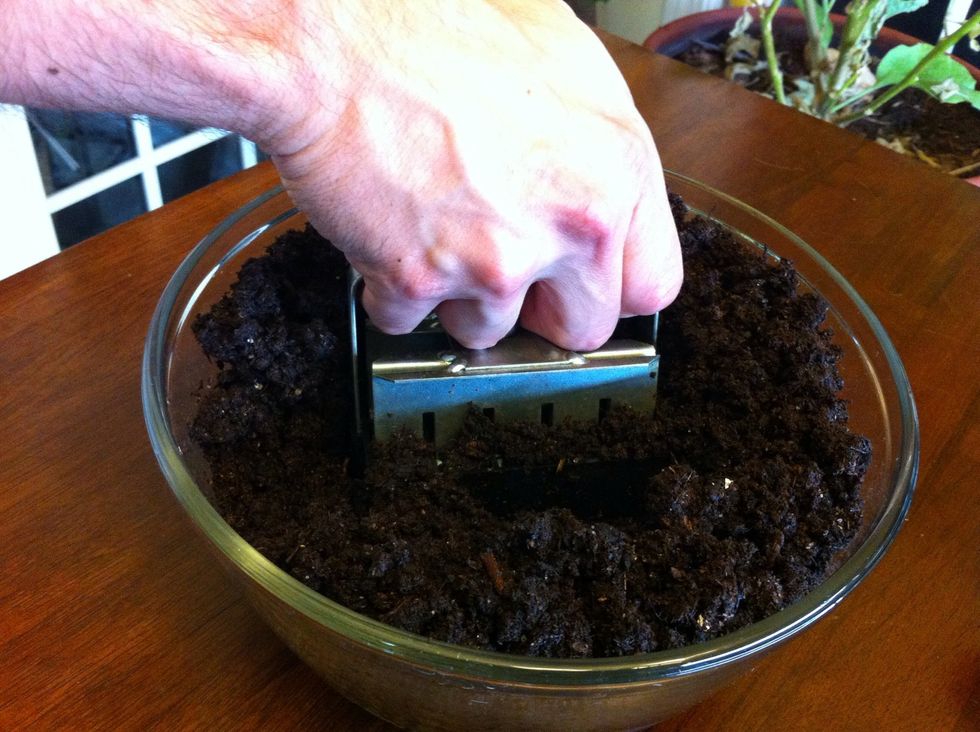 Push soil blocker into soil, twisting slightly back and forth as you push down. Soil should be firmly packed into each blocker cube before placing cubes on seedling tray.