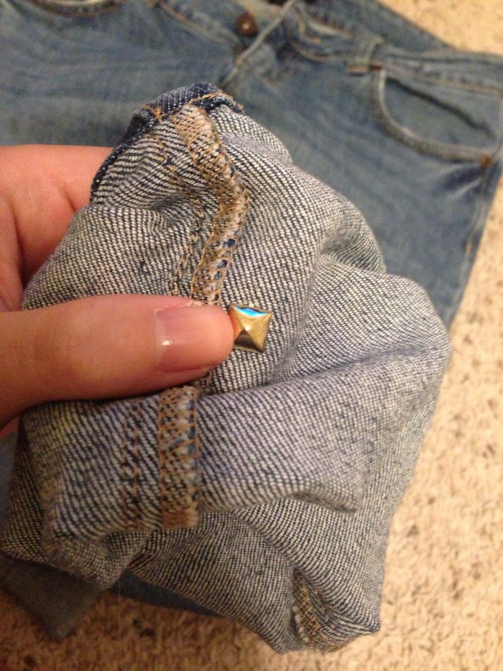 Push stud through the fabric going from the bottom, up and front to back.