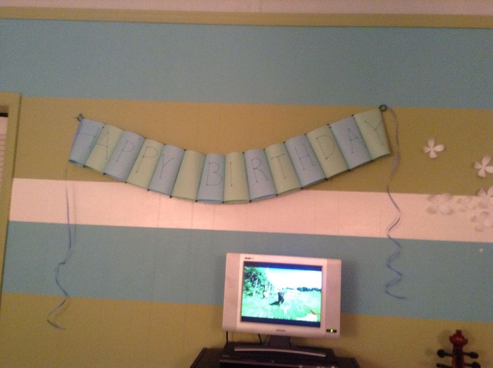 Push tacks or nails into the wall and hang the banner from the pipe cleaner circles!