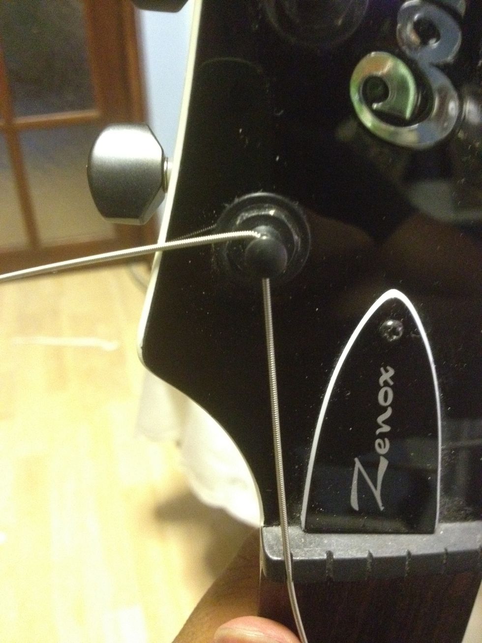 Push that amount of the string back through hole, and bend it to the side as to keep it in place