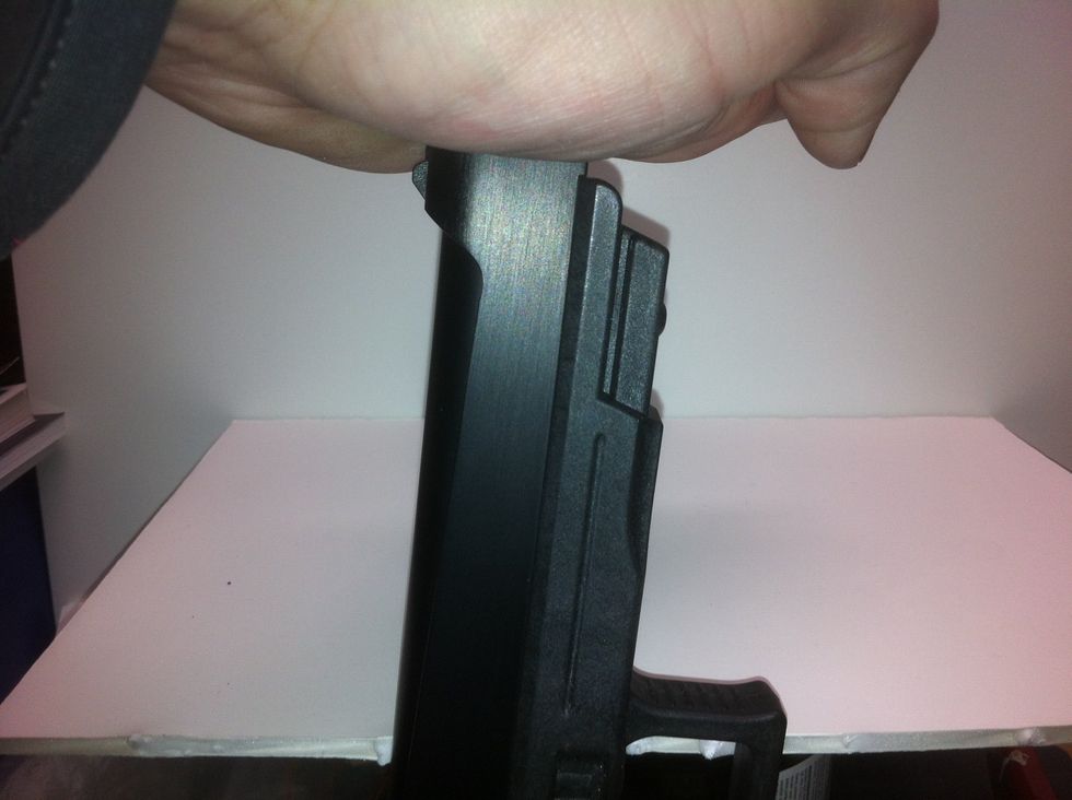 Push the barrel back towards the trigger and rotate counter clockwise.