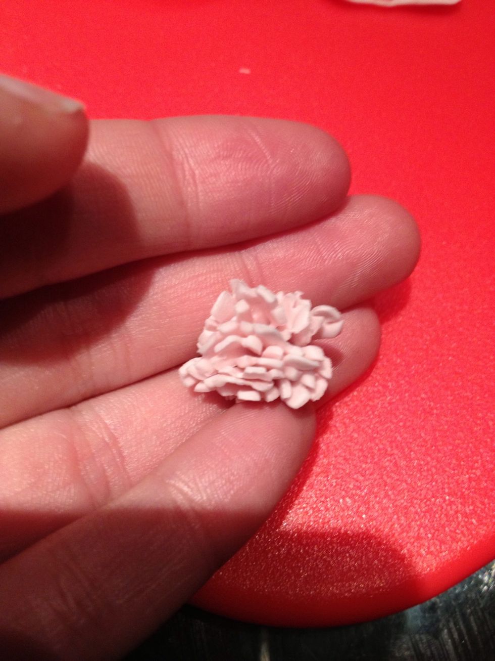 Push the bottom of the first folded flower and squeeze together