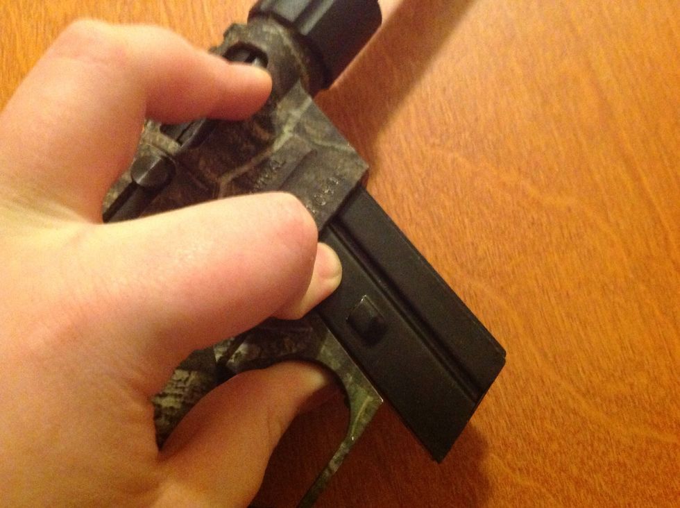 Push the button in front of the trigger to release the clip.