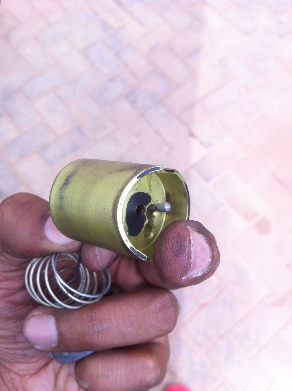 Push the cable end through the slot to the bigger hole to free the cable out of the piston.