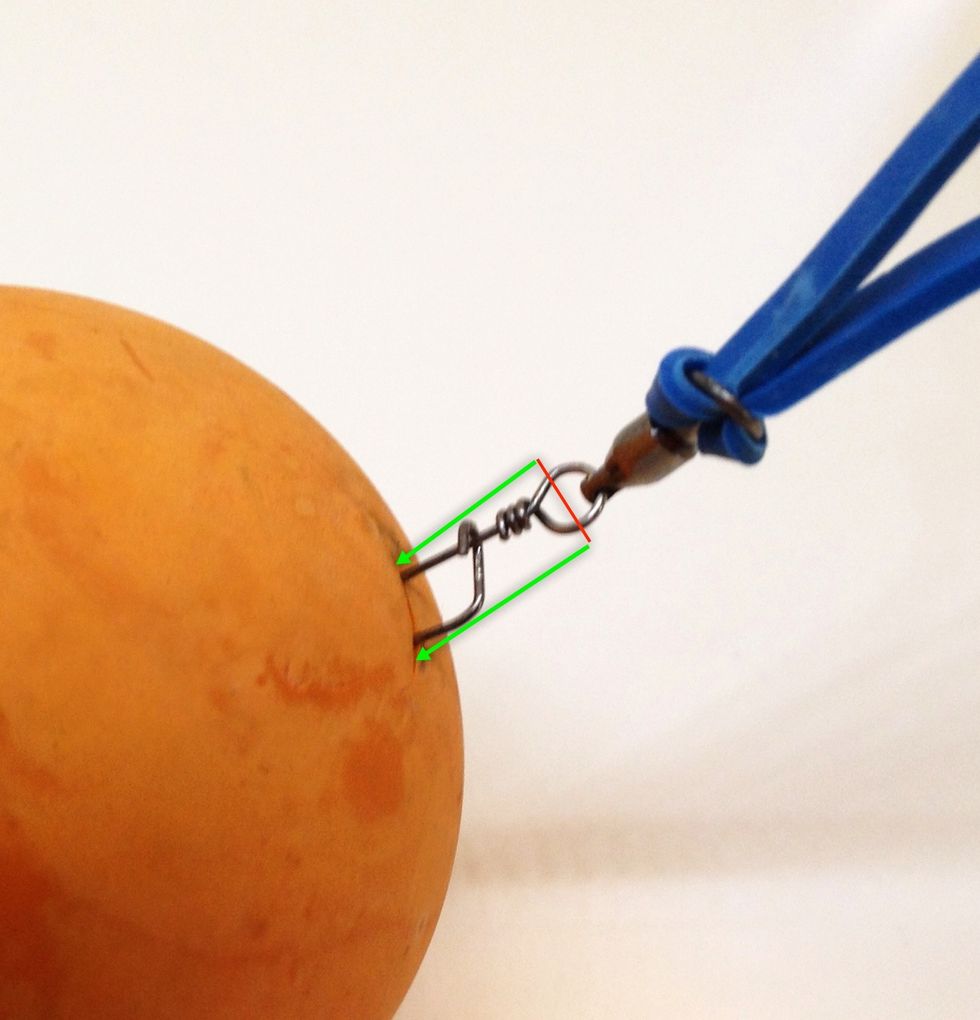 Push the end of the swivel with the snap through the cut. Use the letter opener (or screwdriver) to help. It's important to get the whole snap into the ball (up to the red line in the picture).