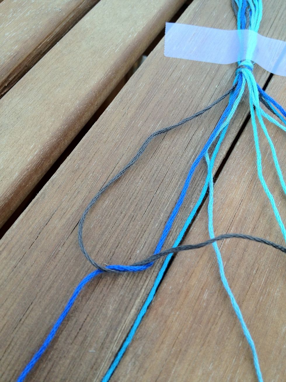 Push the first string underneath the second and pull. In other words, create a left hand knot. It's very important that you cross the first string over the second when you knot, or else it won't work.