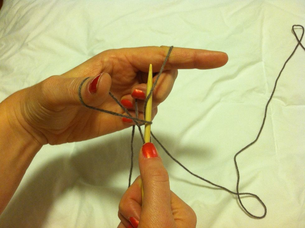 Push the needle through the loop around your pointer finger back towards the center of your hand.