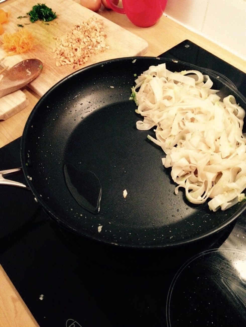 Push the noodles to one side and push the pan slightly off from the heat. Heat some more oil.