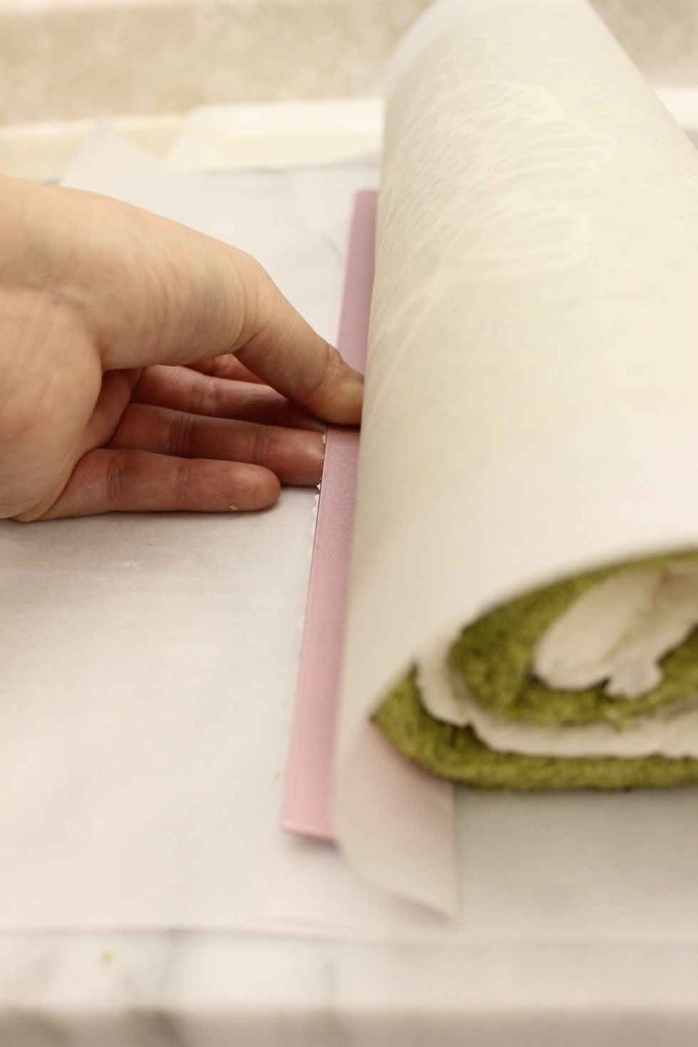 Push the paper under the roll...