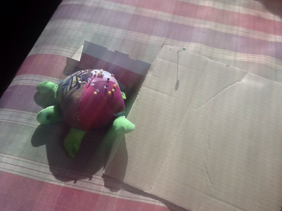 Push the pin or needle you are using through the piece of cardboard you just cut out. Do that again right next to the hole you just made to create holes for your pair of earrings.