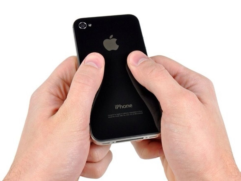 Push the rear panel toward the top edge of the iPhone. The panel will move about 2 mm.
