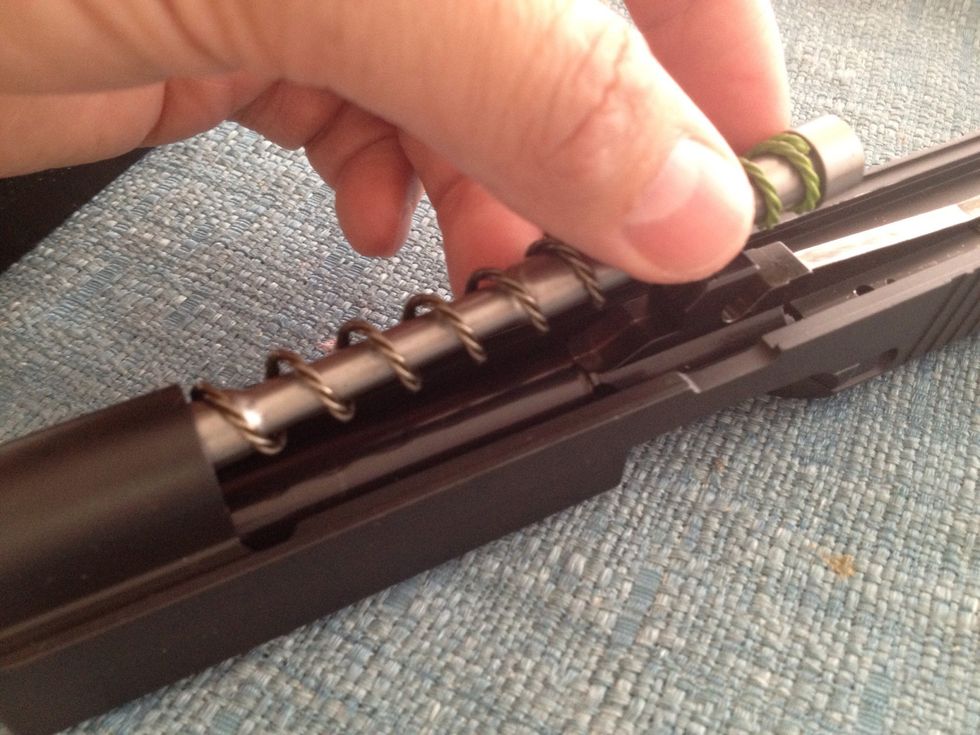 Push the recoil spring guide forward slightly and lift from rear to remove the recoil spring and guide from the slide.