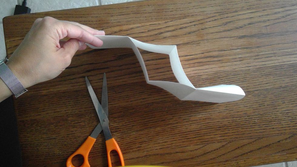 Push the slit in the middle of the paper so it opens up.