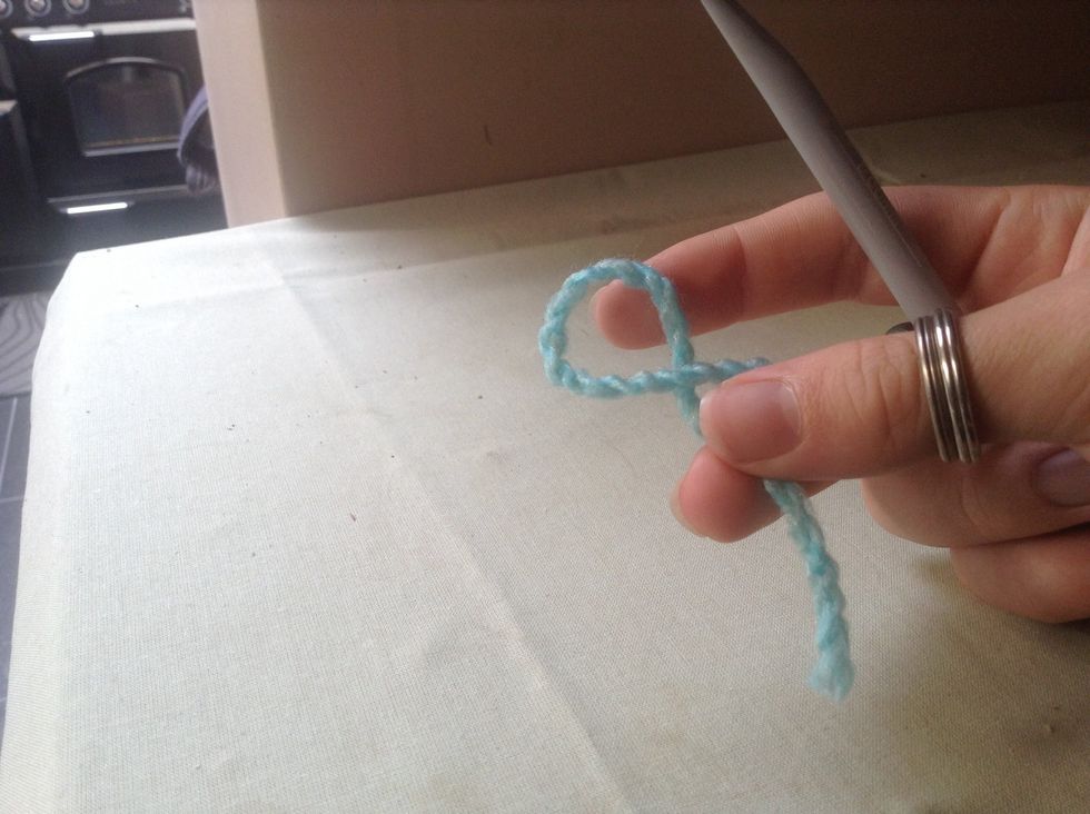 Push the wool together so the wool in your right hand crosses over the wool in your left hand and makes a loop.