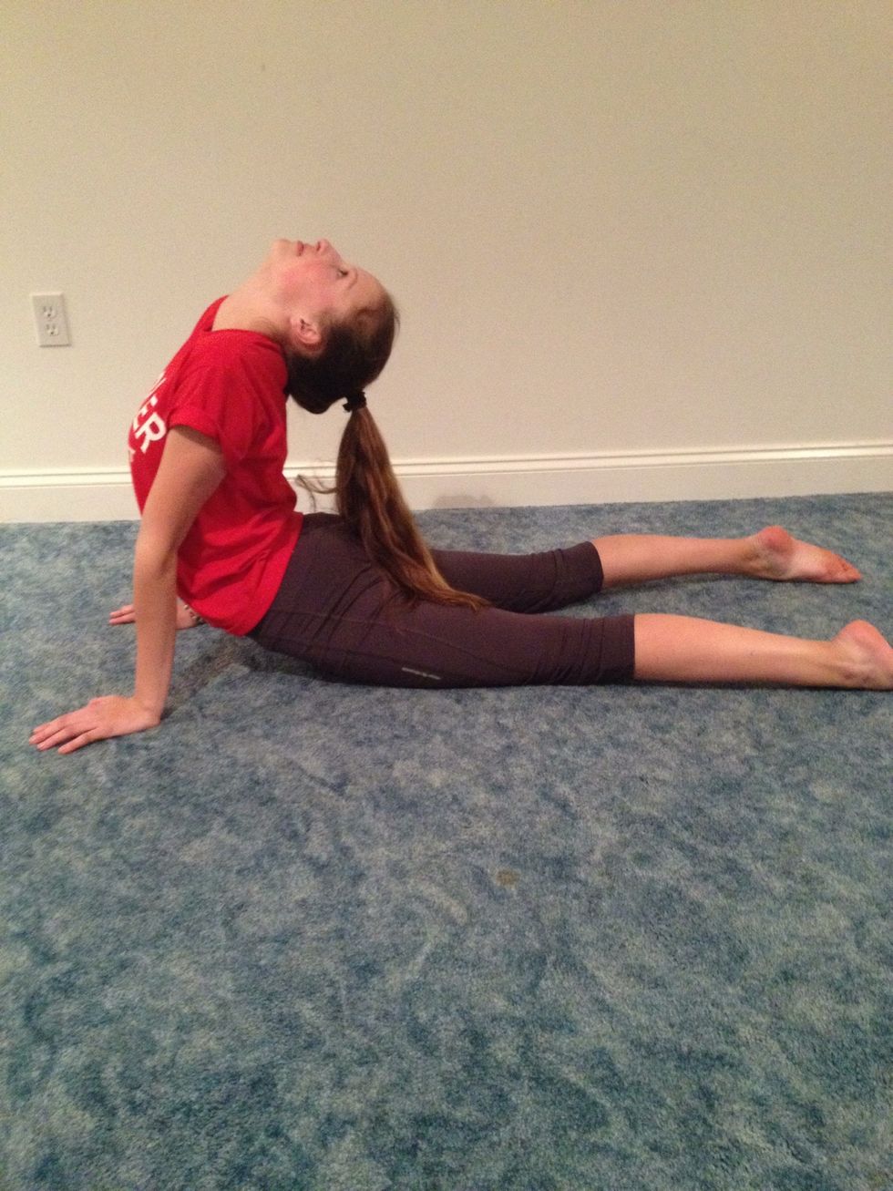 Push your legs back straight and arch your back as much as you can. Try to keep your hips on the ground.