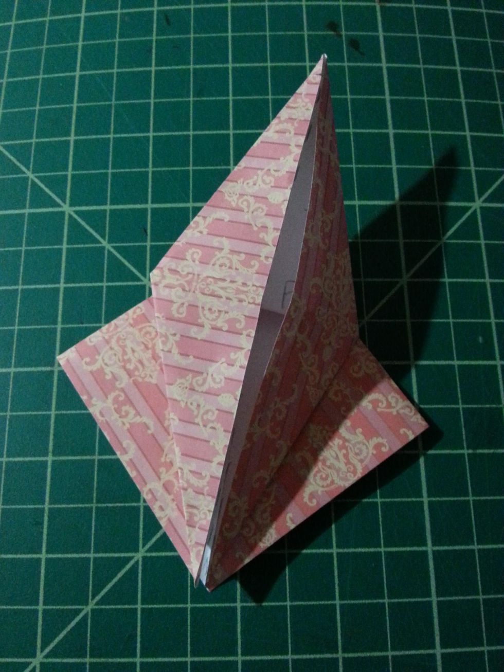 Pushing both flaps in towards each other and flatten down, your shape should look like the one on your left.