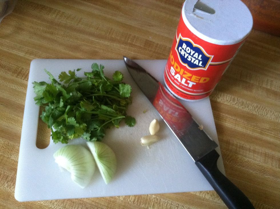 Put 1/2 bunch of cilantro, 2 garlic, salt, and 1/2 onion in blender along with jalape\u00f1os and tomatillo.