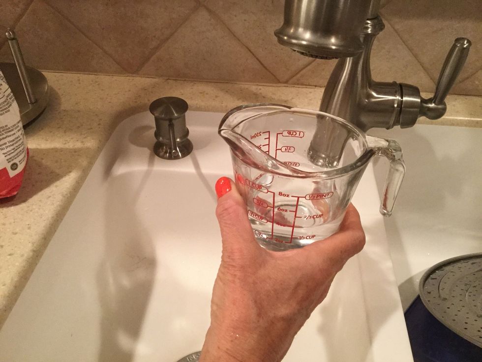 Put 1/2 cup of warm water into a measuring cup or a separate glass bowl.