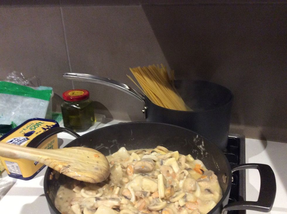 Put 1/2 of the Fettuccine from the packet into the other boiling pot. Check on it every 2 minutes and if they're sinking in the water, stir them for 30 seconds.