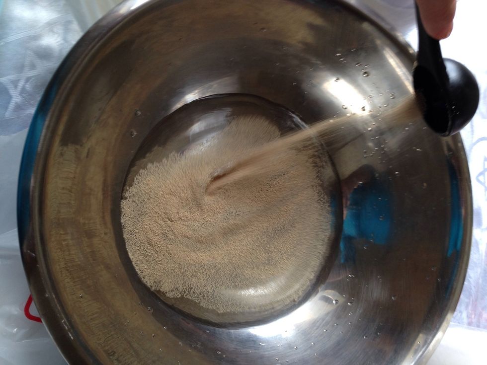 Put 1 and 3/4 cup Luke warm water in a big mixing bowl. Add 2T yeast