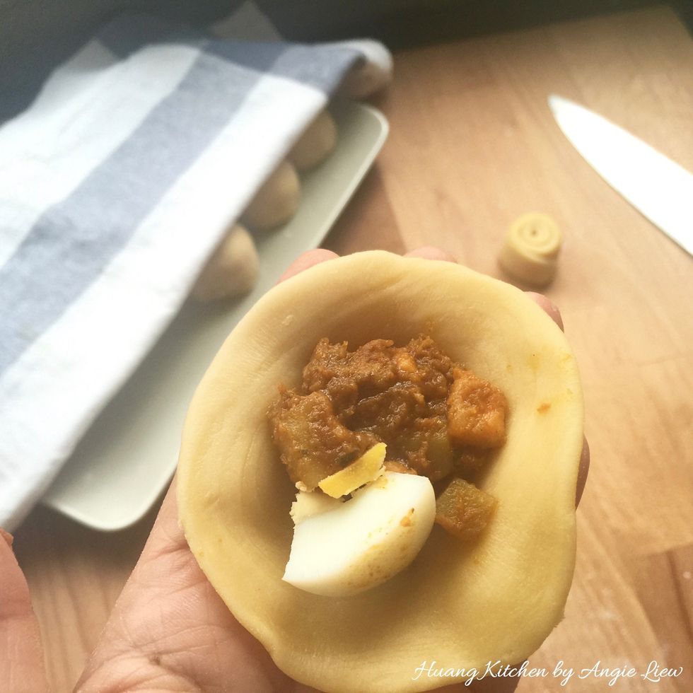 Put 1 tablespoon of curry meat filling and a slice of egg in the centre of the flattened UNCUT side.