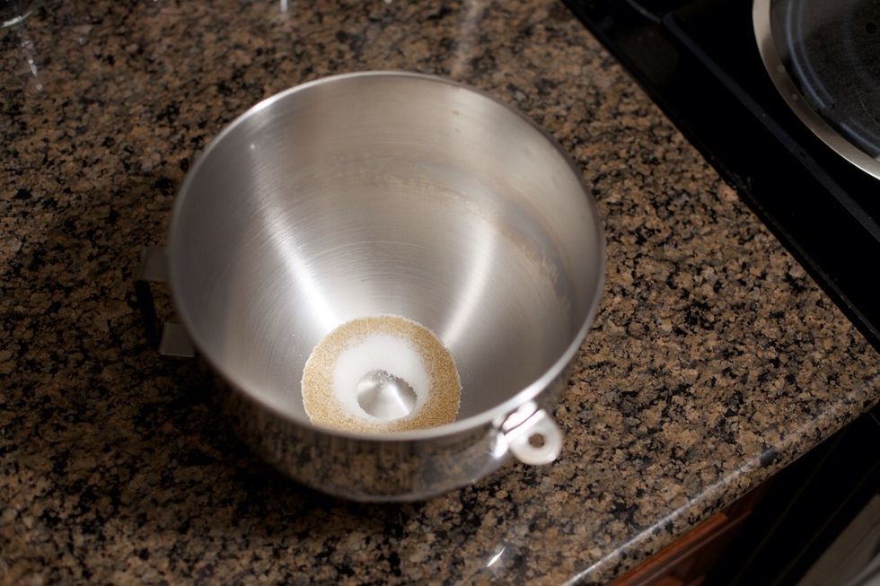 Put 1 teaspoon of white sugar and 2 teaspoons yeast into the bowl.