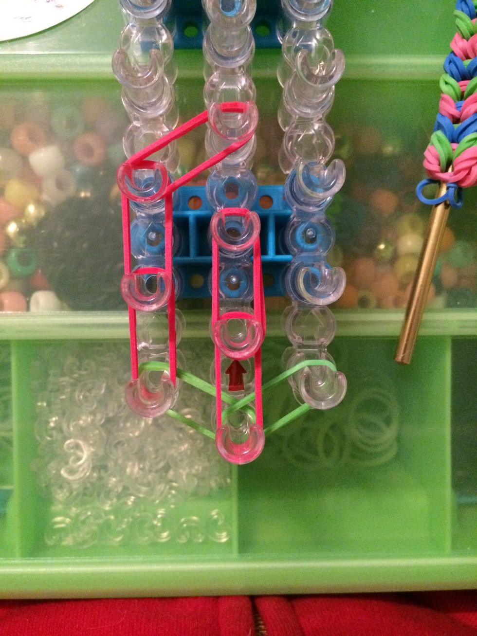 Put 2 more red bands on the second and third pegs on the center row.