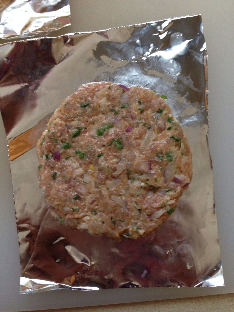 Put a ball of meat on the foil and using wet hands flatten it a little