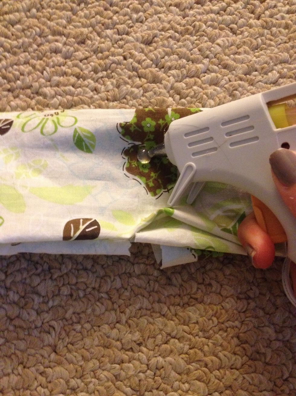 Put a bead of glue close to the top of the fabric