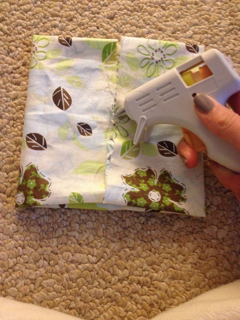 Put a bead of glue in the center if your fabric like so...