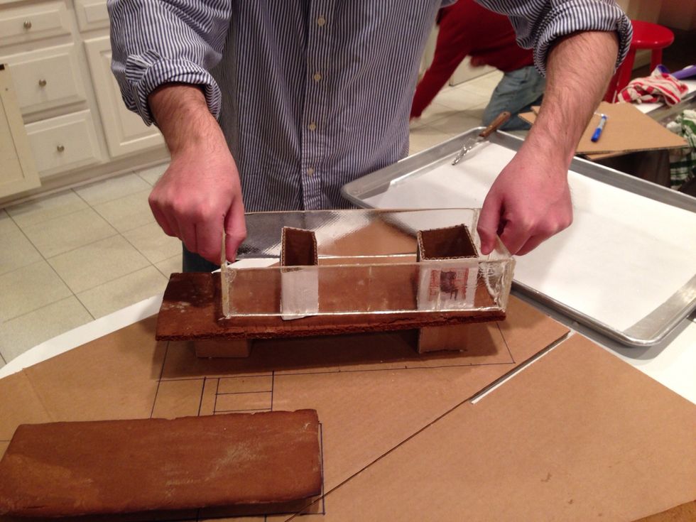 Put a bit of icing/glue on the bottom of the glass. Carefully. You don't want to be the one who goofs it up now.