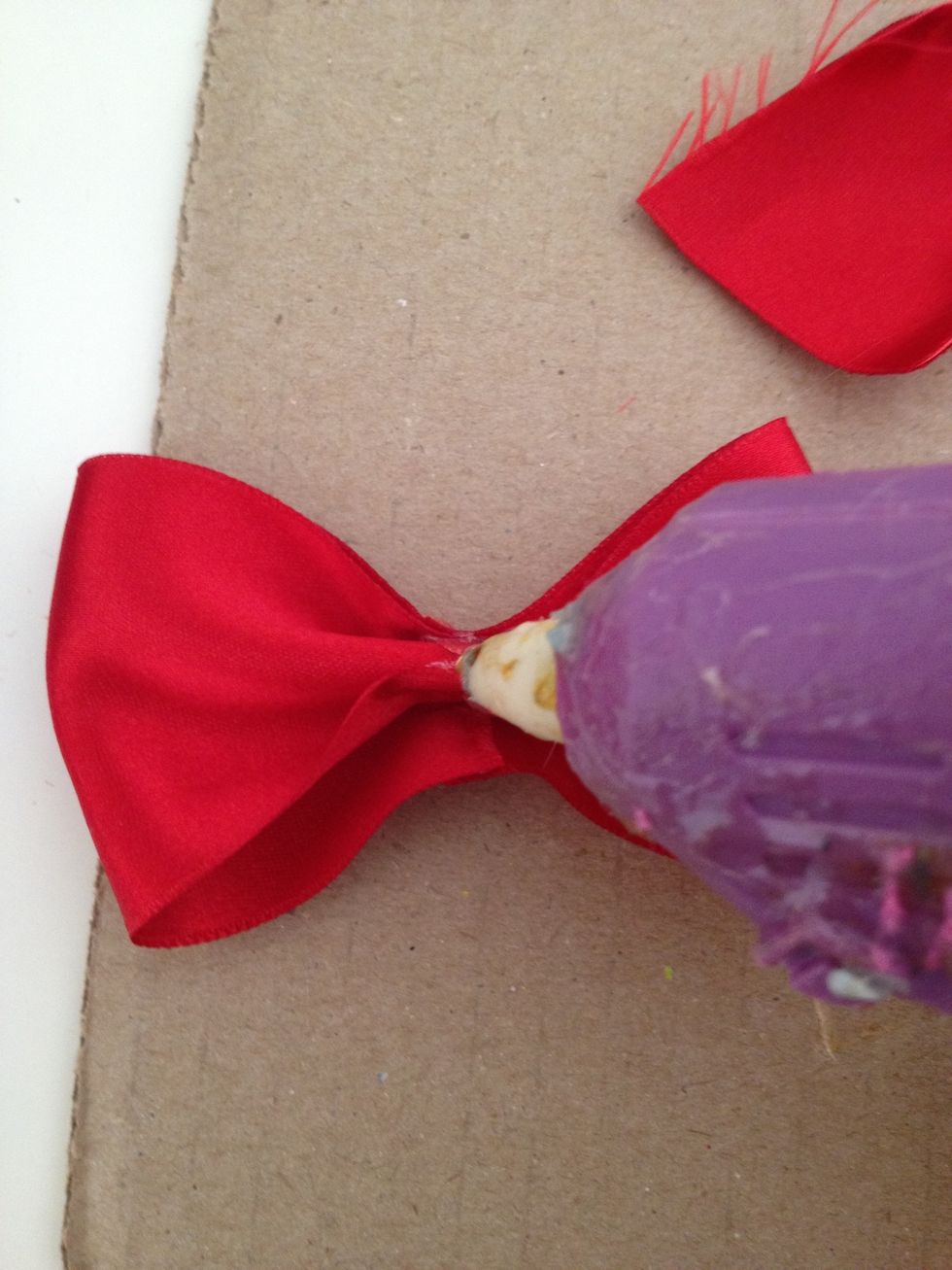 put a dab of glue on the back and stick one side of the other peace of ribbon to it