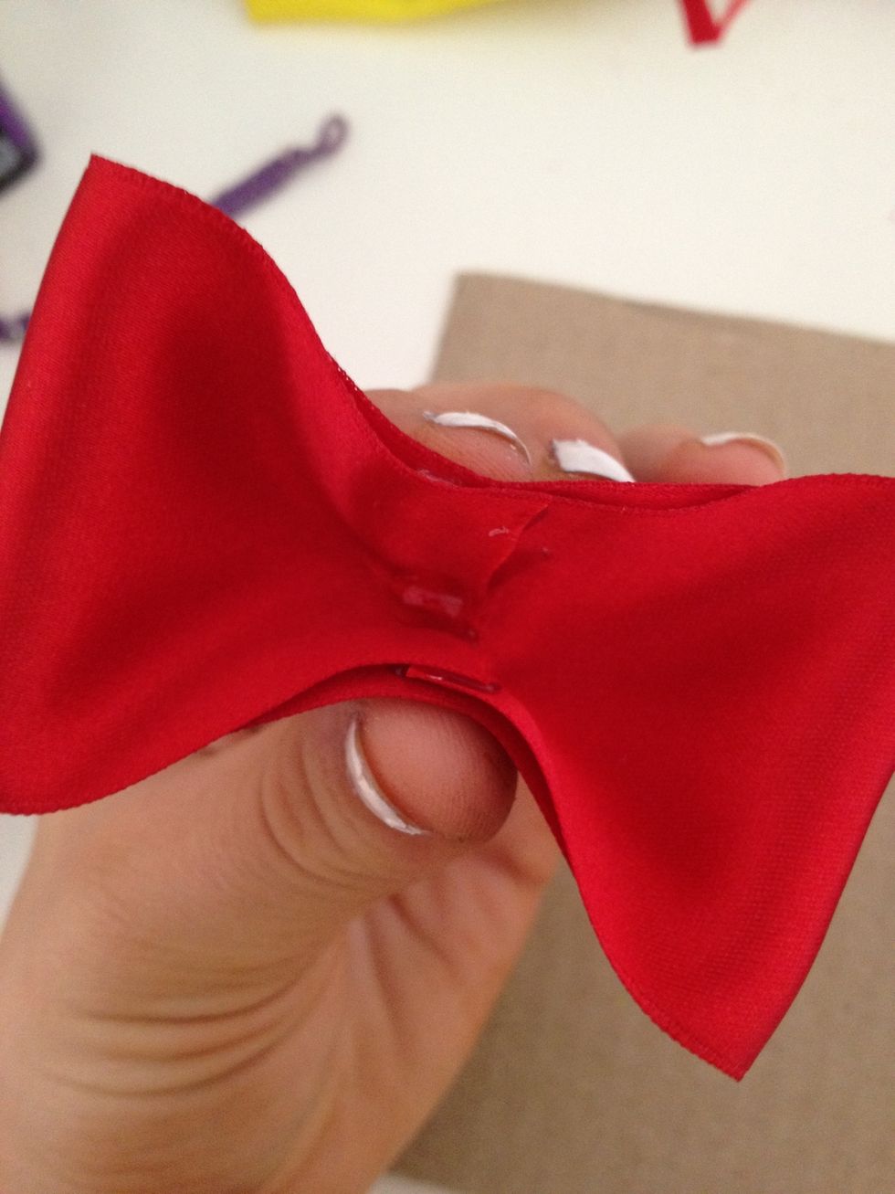 put a dab of glue right in the center and fold the whole thing in half longways